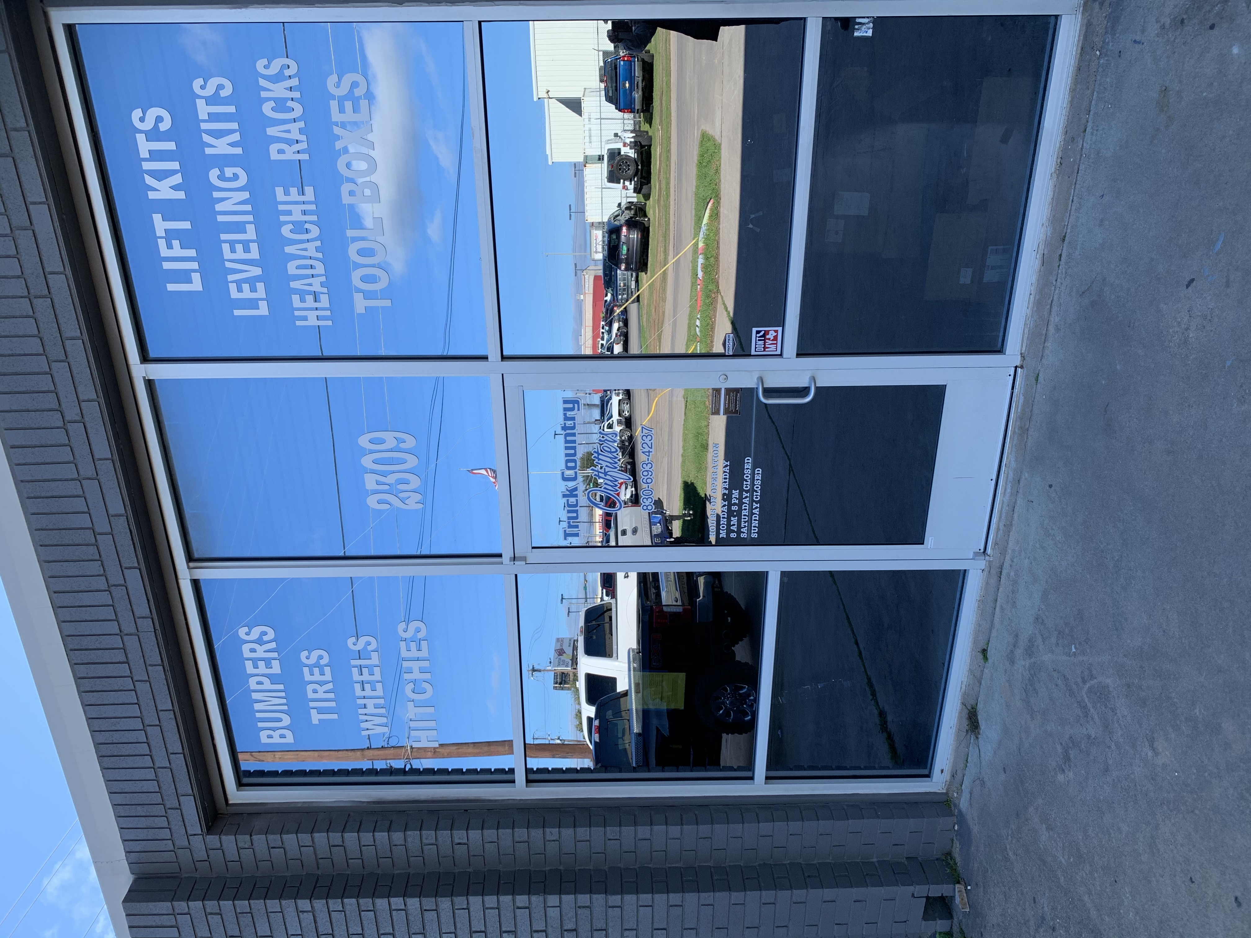 Truck Country Outfitters storefront close-up showing hours, phone number, and services — Marble Falls TX 78654