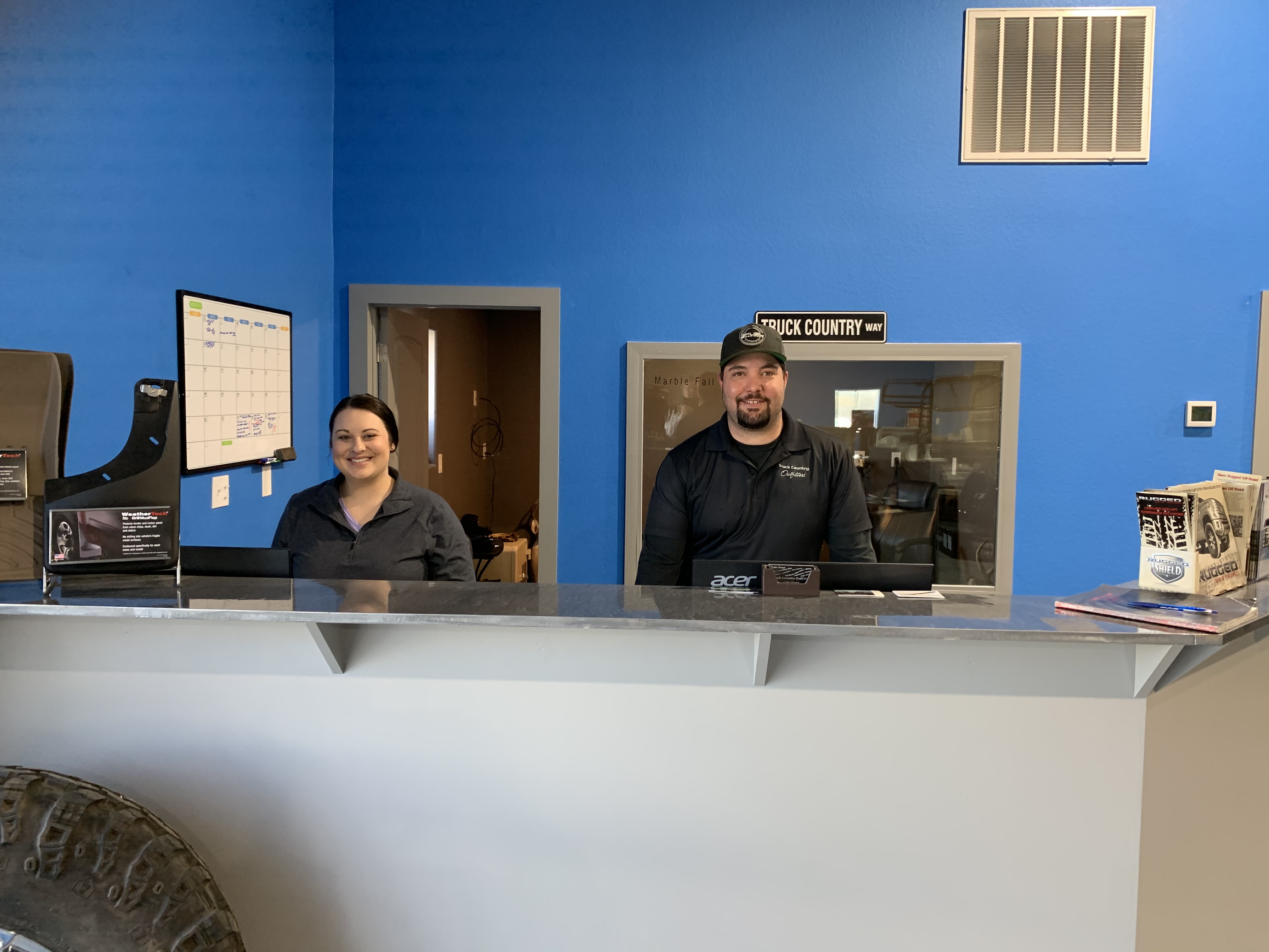 Truck Country Outfitters staff behind the service counter with "Truck Country Way" sign — Marble Falls, TX